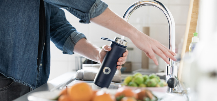 personal filling water bottle in kitchen